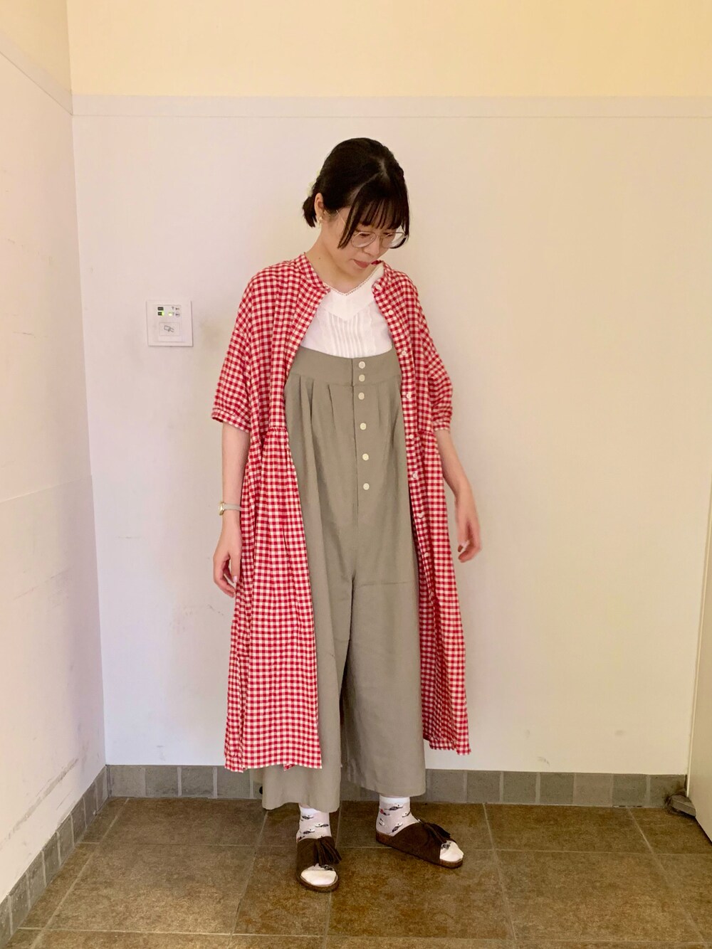ブラウン系のサンダル、グレー系のサロペット/オーバーオール、ホワイト系のTシャツ/カットソーを着用したレディースの夏コーディネートの1枚目の写真