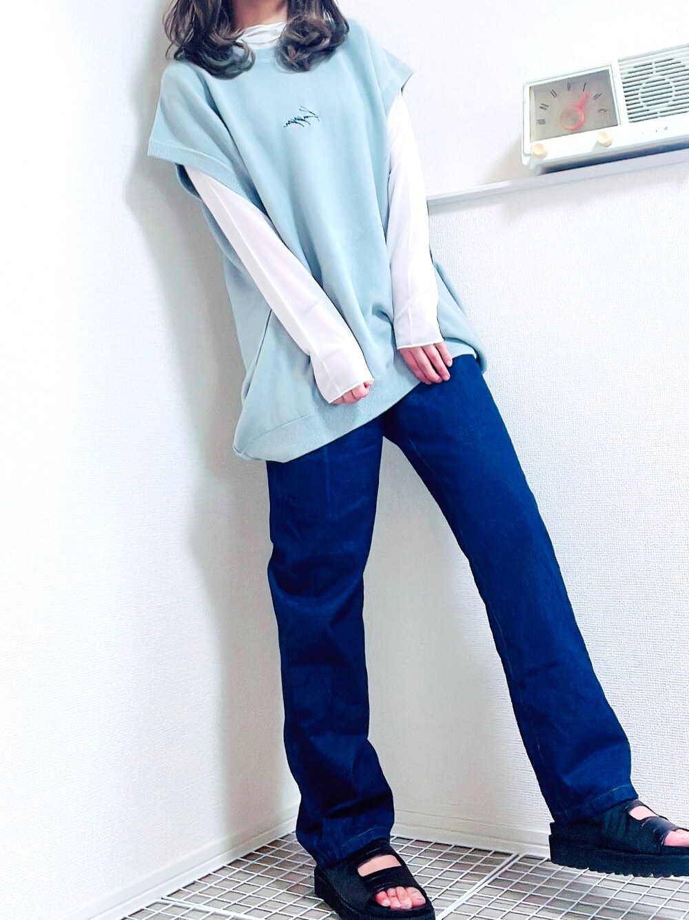 ホワイト系のトップス、ホワイト系のベスト、ブルー系のデニムパンツを着用したレディースの夏コーディネートの1枚目の写真