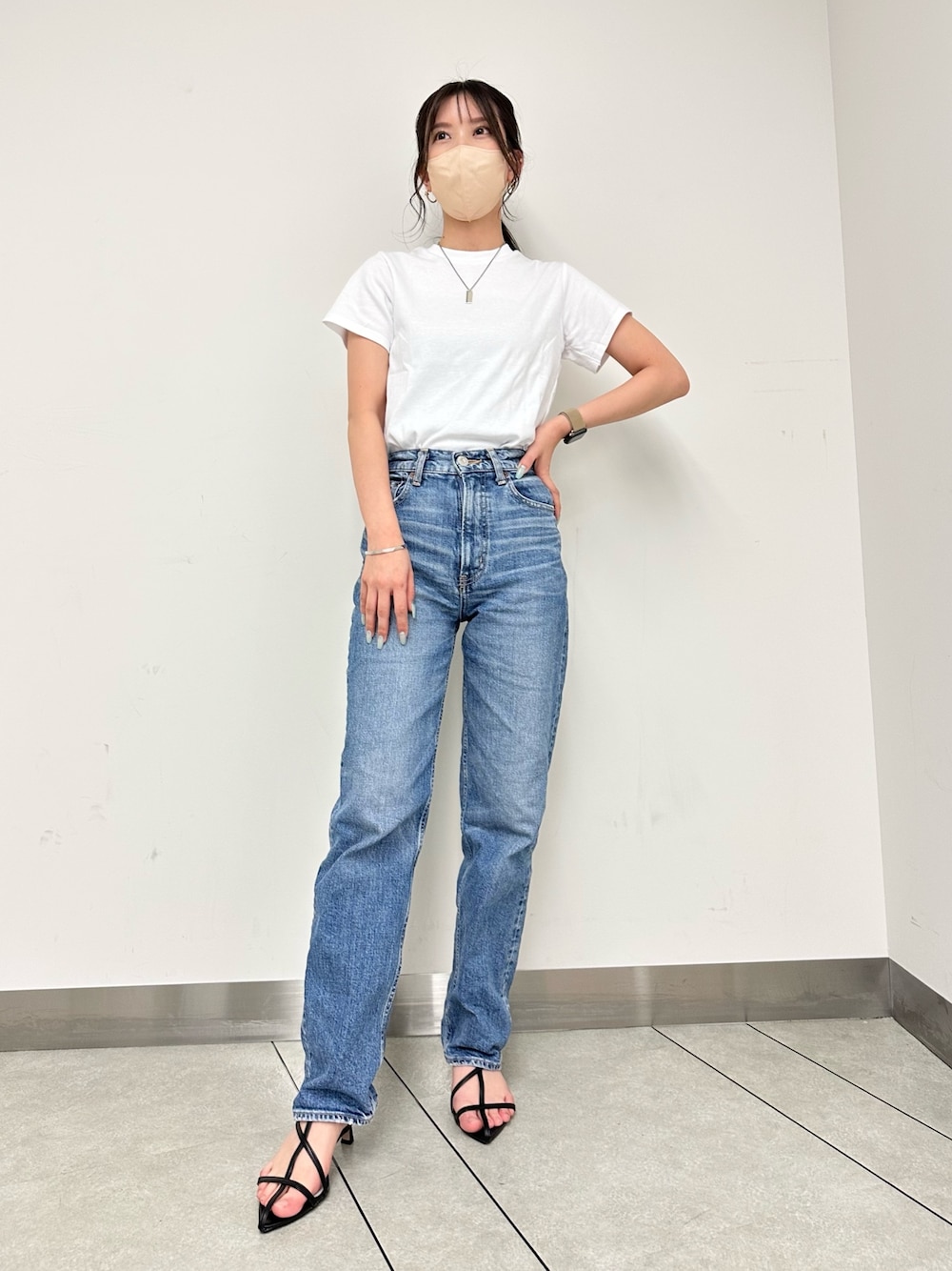 ブルー系のデニムパンツ、ブラック系のサンダル、シルバー系のバングル/リストバンドを着用したレディースの春コーディネートの1枚目の写真