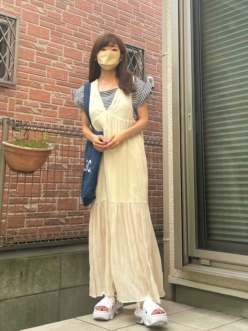 ホワイト系のサンダル、ブラック系のTシャツ/カットソー、ホワイト系のワンピースを着用したレディースの夏コーディネートの1枚目の写真