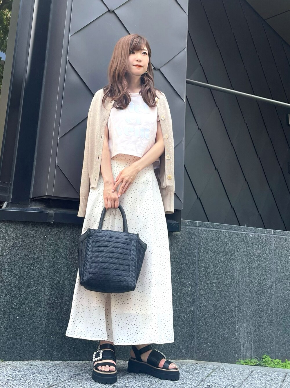 ピンク系のTシャツ/カットソー、ホワイト系のスカート、ブラック系のかごバッグを着用したレディースの春コーディネートの1枚目の写真