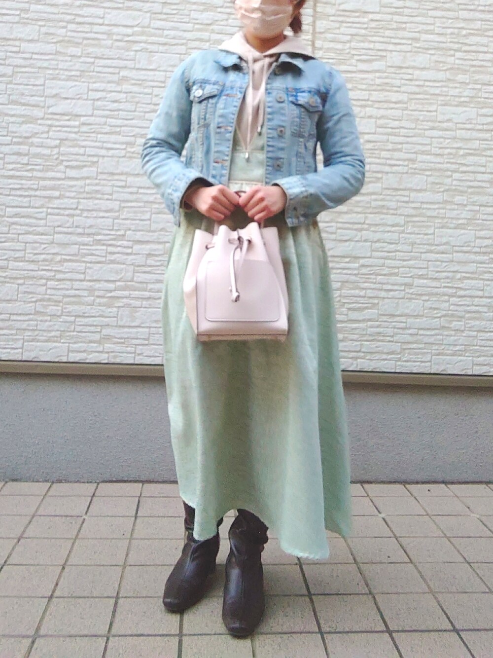 ホワイト系のバッグ、ベージュ系のパーカー、ブルー系のデニムジャケットを着用したレディースの春コーディネートの3枚目の写真