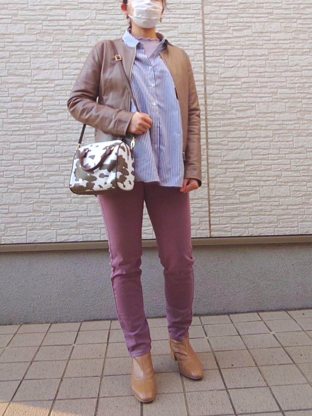 ピンク系のパンツ、イエロー系のブーツ、ブラウン系のノーカラージャケットを着用したレディースの春コーディネートの2枚目の写真