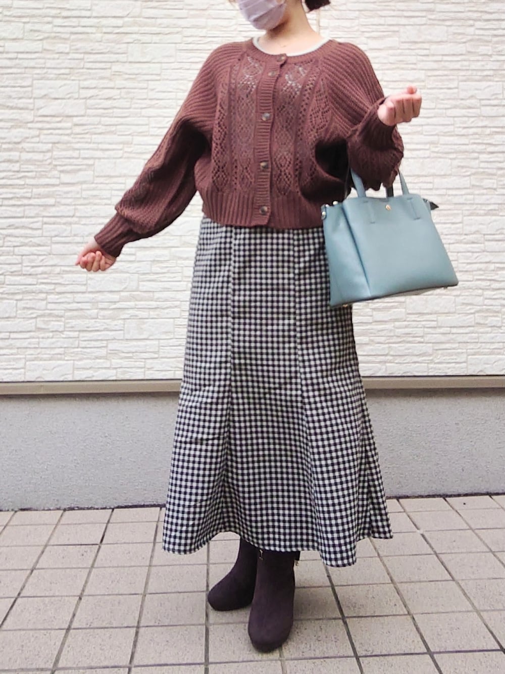 グリーン系のバッグ、グリーン系のニット/セーター、その他のスカートを着用したレディースの冬コーディネートの2枚目の写真