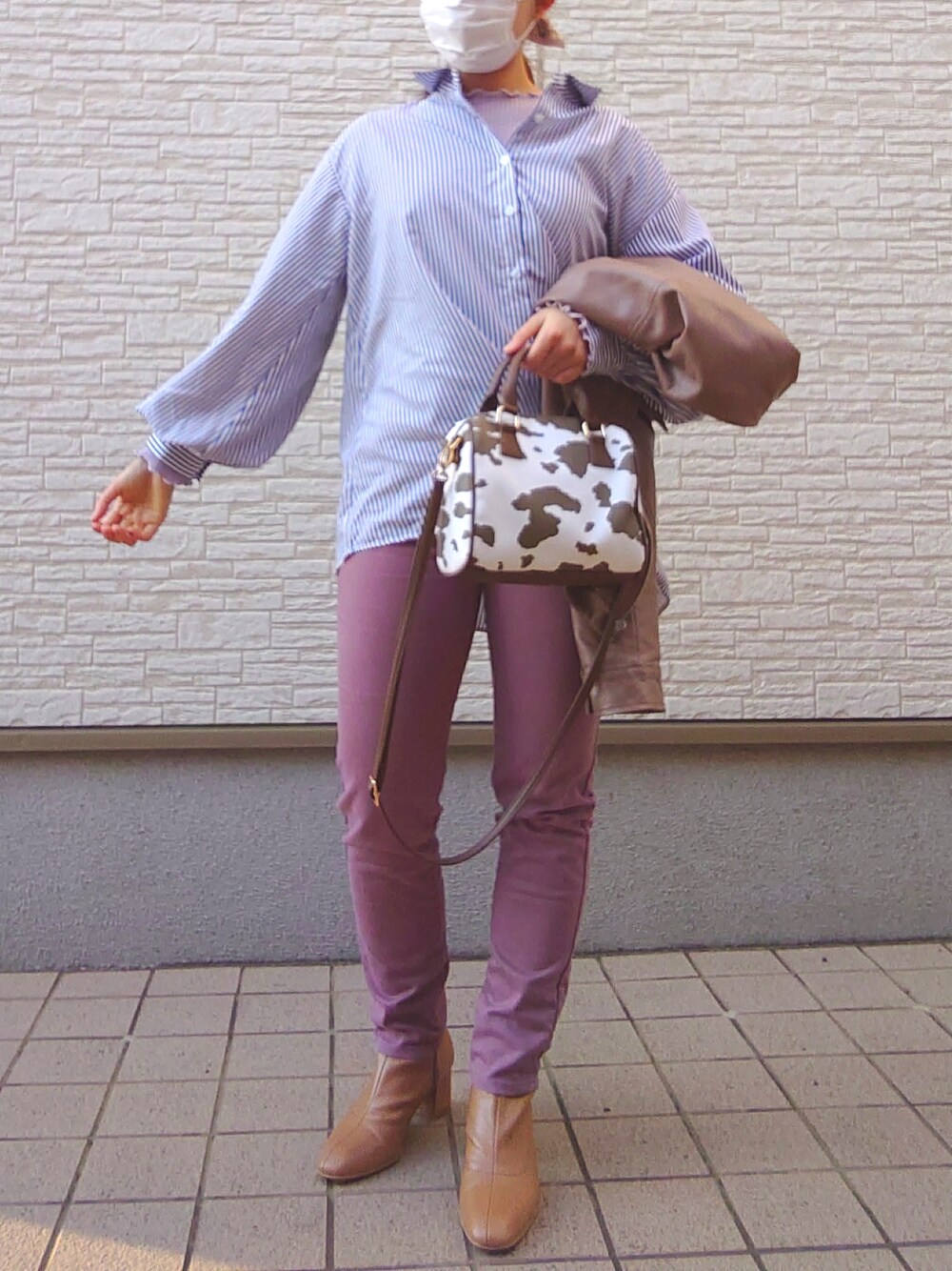 ピンク系のパンツ、イエロー系のブーツ、ブラウン系のノーカラージャケットを着用したレディースの春コーディネートの3枚目の写真