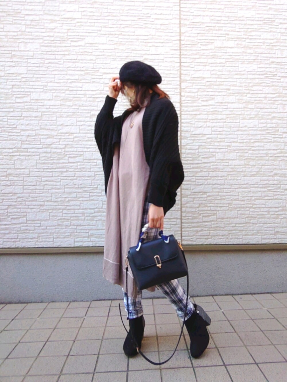 ブラウン系のベスト、ブラック系のショルダーバッグ、ブラック系のブーツを着用したレディースの冬コーディネートの1枚目の写真