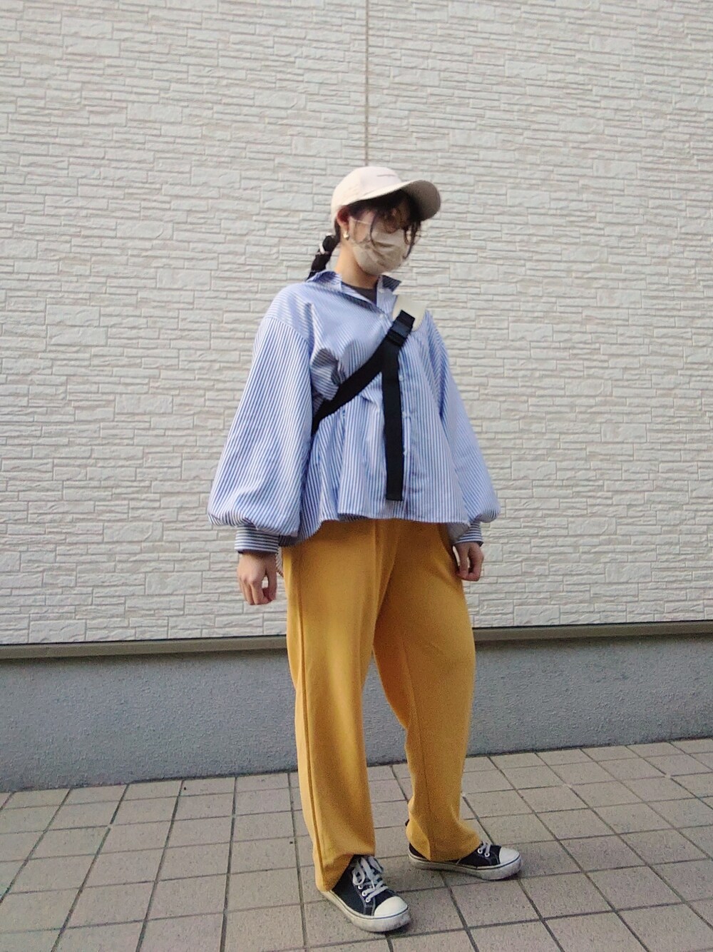 ブルー系のシャツ/ブラウス、イエロー系のパンツ、ブラック系のスニーカーを着用したレディースの春コーディネートの2枚目の写真