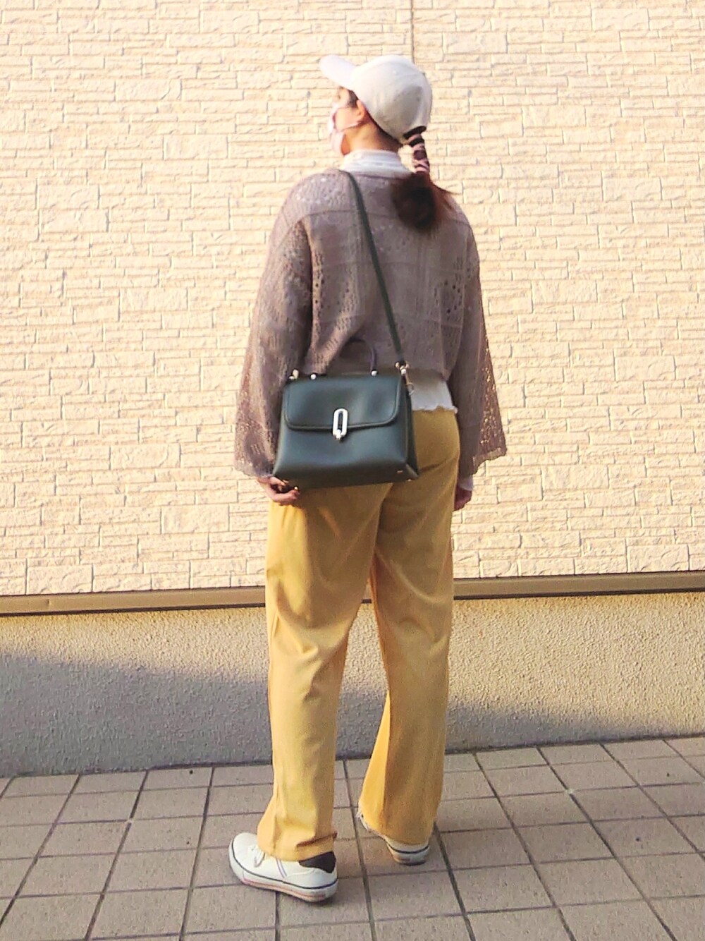 グリーン系のトップス、ホワイト系のトップス、イエロー系のパンツを着用したレディースの春コーディネートの3枚目の写真