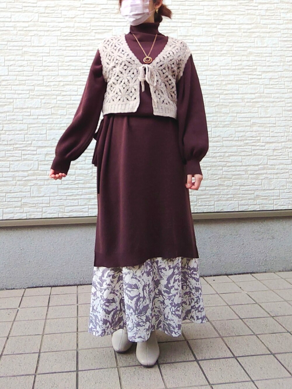 ブラウン系のワンピース/ドレス、グレー系のスカート、ホワイト系のブーツを着用したレディースの冬コーディネートの2枚目の写真