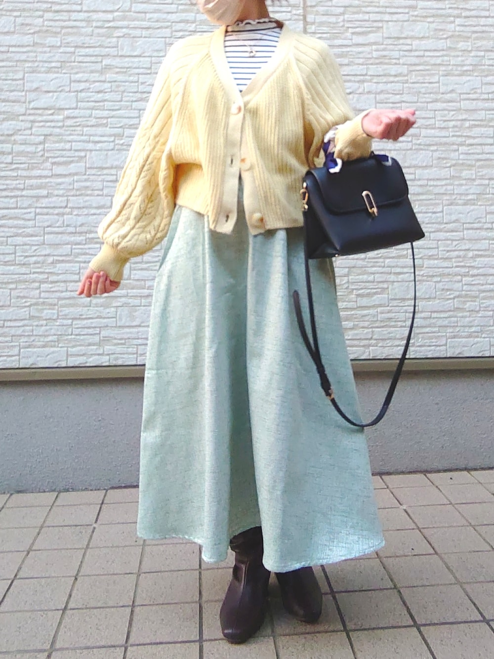 ブルー系のTシャツ/カットソー、パープル系のニット/セーター、ホワイト系のバッグを着用したレディースの春コーディネートの2枚目の写真