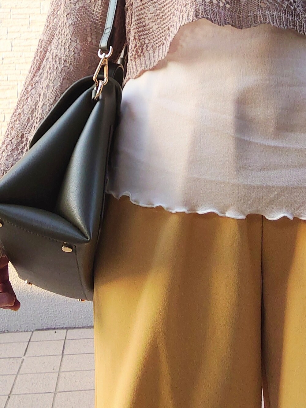 グリーン系のトップス、ホワイト系のトップス、イエロー系のパンツを着用したレディースの春コーディネートの4枚目の写真