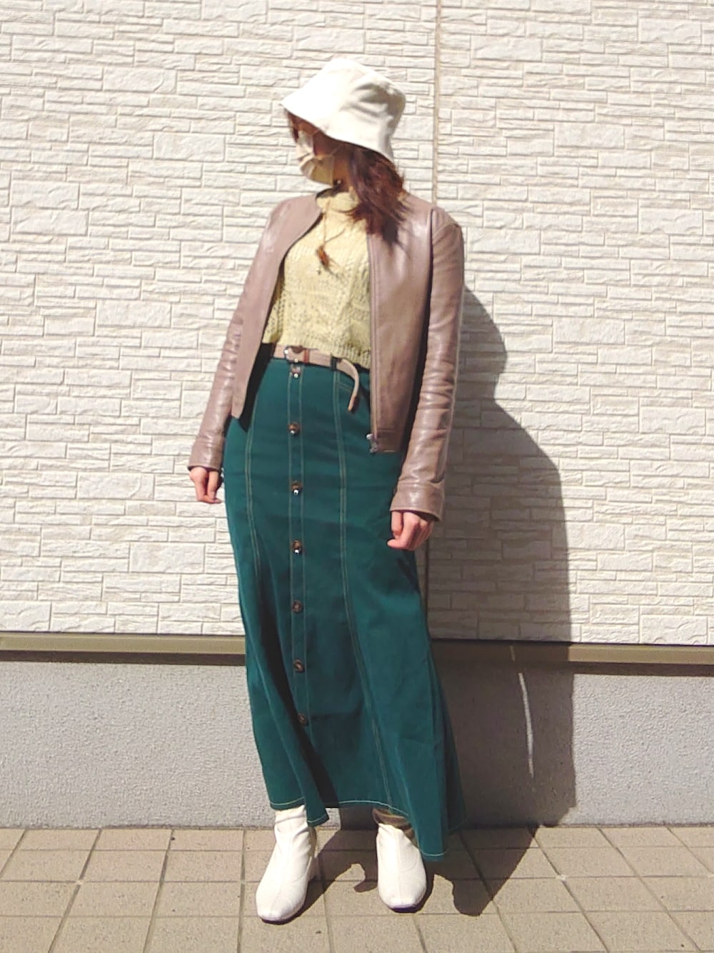 グリーン系のトップス、グリーン系のスカート、ブラウン系のノーカラージャケットを着用したレディースの春コーディネートの3枚目の写真