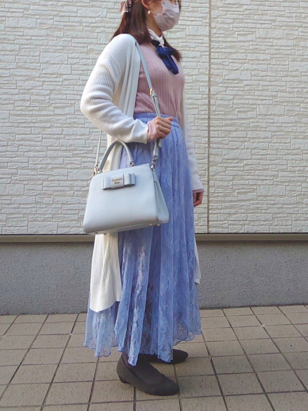 ブルー系のスカート、ホワイト系のカーディガン/ボレロ、ピンク系のニット/セーターを着用したレディースの春コーディネートの2枚目の写真