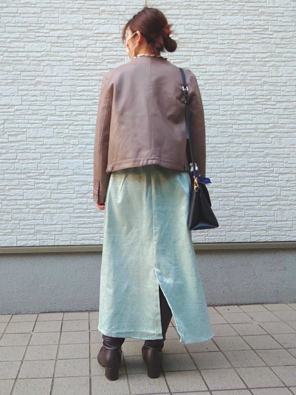 ブラウン系のノーカラージャケット、ブルー系のTシャツ/カットソー、ブラック系のショルダーバッグを着用したレディースの春コーディネートの2枚目の写真