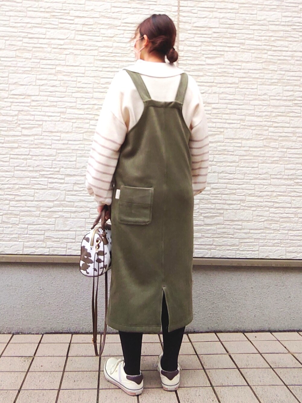 その他のボストンバッグ、ベージュ系のトップス、グリーン系のジャンパースカートを着用したレディースの冬コーディネートの2枚目の写真