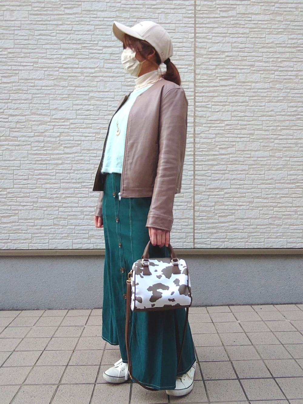 グリーン系のニット/セーター、ホワイト系のトップス、ブラウン系のノーカラージャケットを着用したレディースの冬コーディネートの2枚目の写真