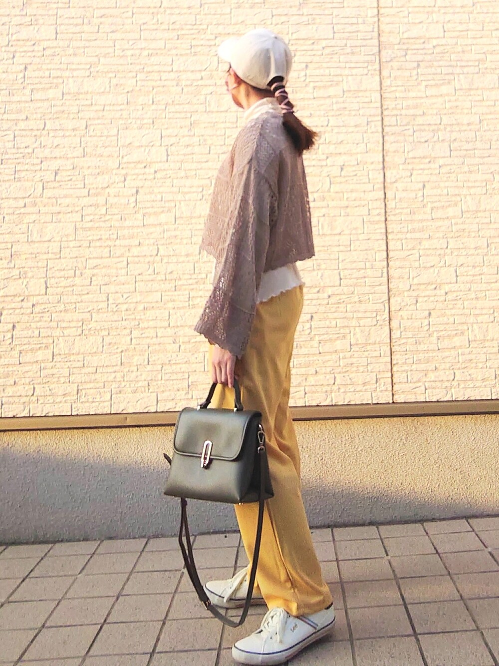 グリーン系のトップス、ホワイト系のトップス、イエロー系のパンツを着用したレディースの春コーディネートの2枚目の写真