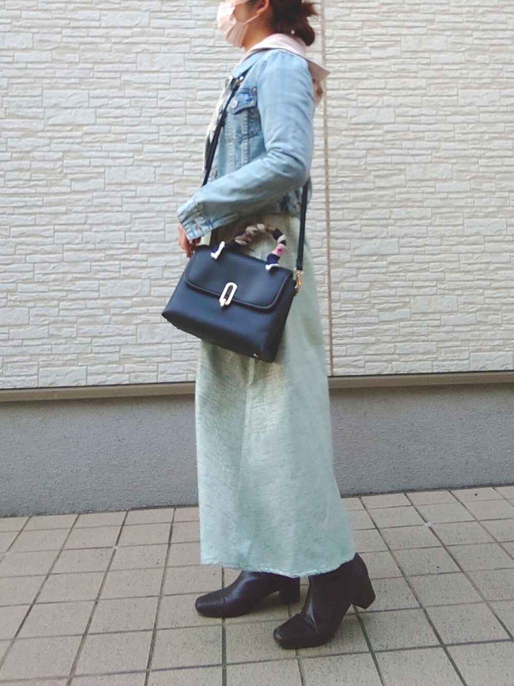 ホワイト系のバッグ、ベージュ系のパーカー、ブルー系のデニムジャケットを着用したレディースの春コーディネートの2枚目の写真