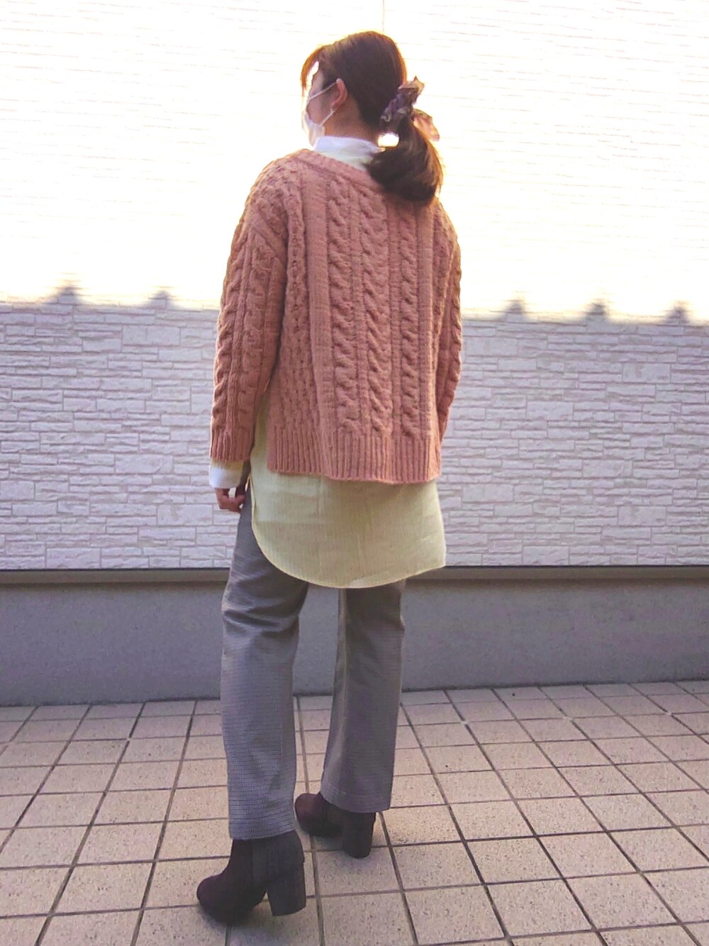 オレンジ系のニット/セーター、その他のパンツ、ブラウン系のブーツを着用したレディースの冬コーディネートの3枚目の写真