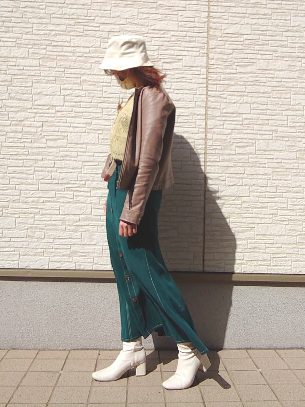 グリーン系のトップス、グリーン系のスカート、ブラウン系のノーカラージャケットを着用したレディースの春コーディネートの4枚目の写真