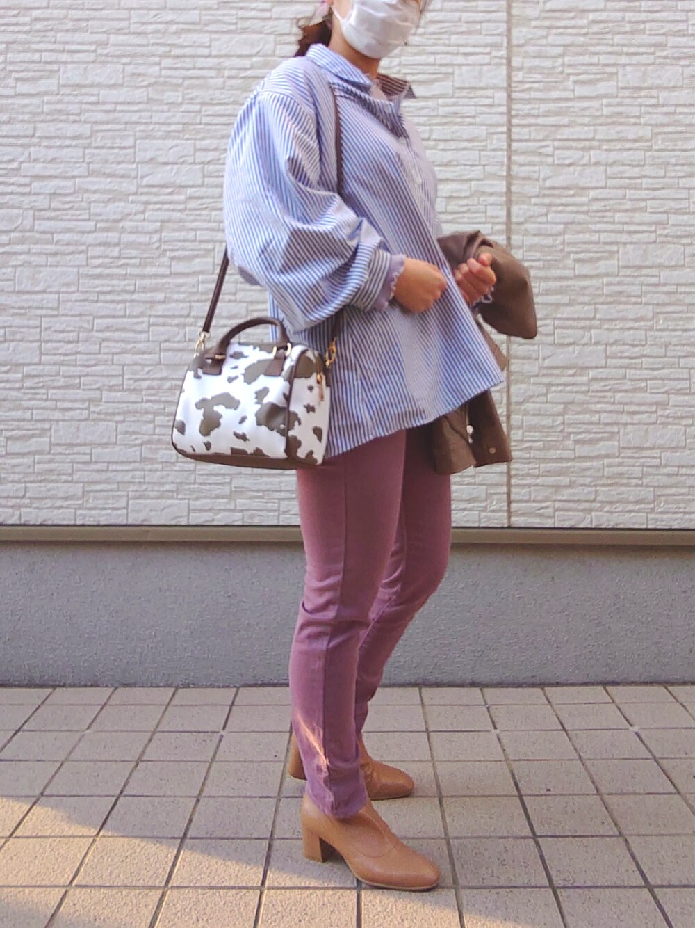 ピンク系のパンツ、イエロー系のブーツ、ブラウン系のノーカラージャケットを着用したレディースの春コーディネートの5枚目の写真