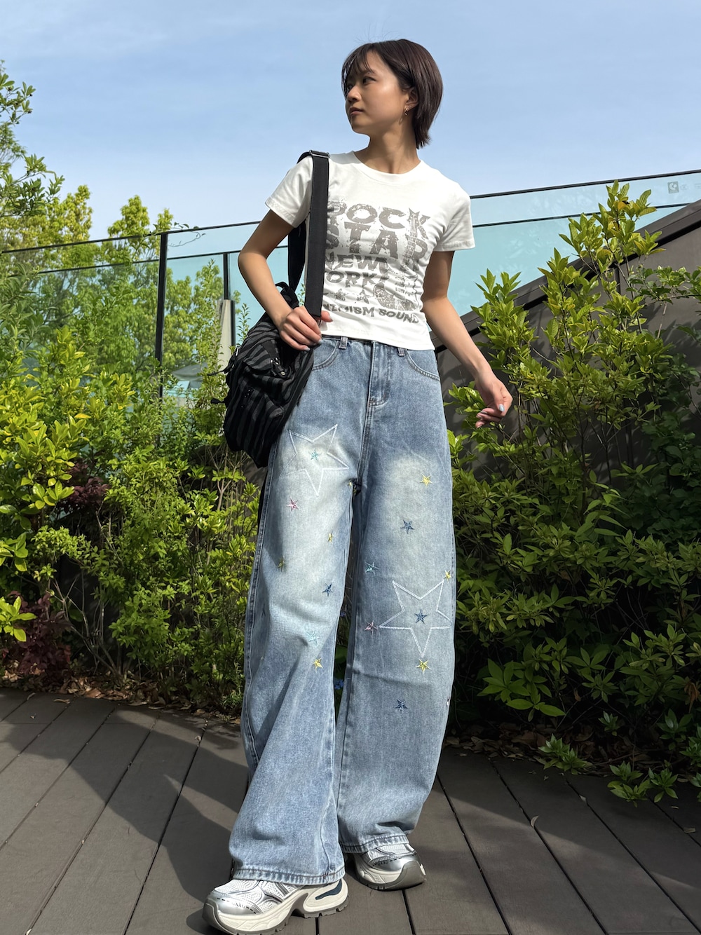 ホワイト系のTシャツ/カットソー、ブルー系のデニムパンツ、ブラック系のバックパック/リュックを着用したレディースの春コーディネートの1枚目の写真