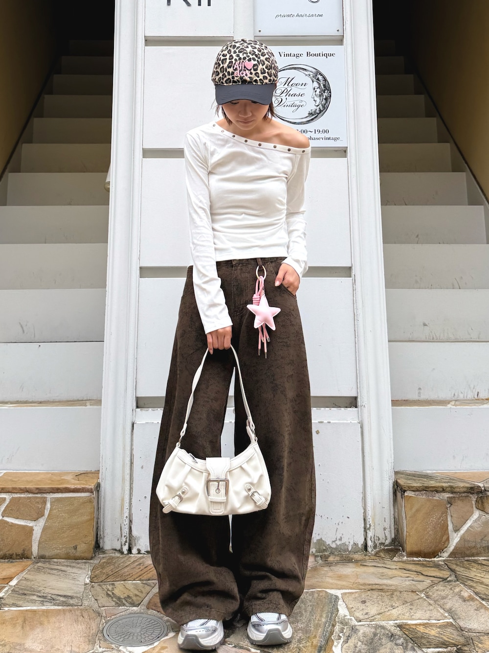 ホワイト系のTシャツ/カットソー、ブラウン系のデニムパンツ、ホワイト系のショルダーバッグを着用したレディースの秋コーディネートの1枚目の写真