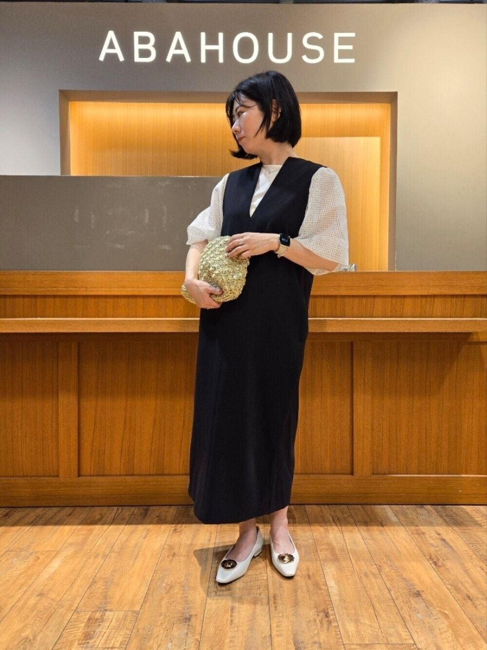 ブラック系のワンピース、ホワイト系のTシャツ/カットソーを着用したレディースの春コーディネートの1枚目の写真