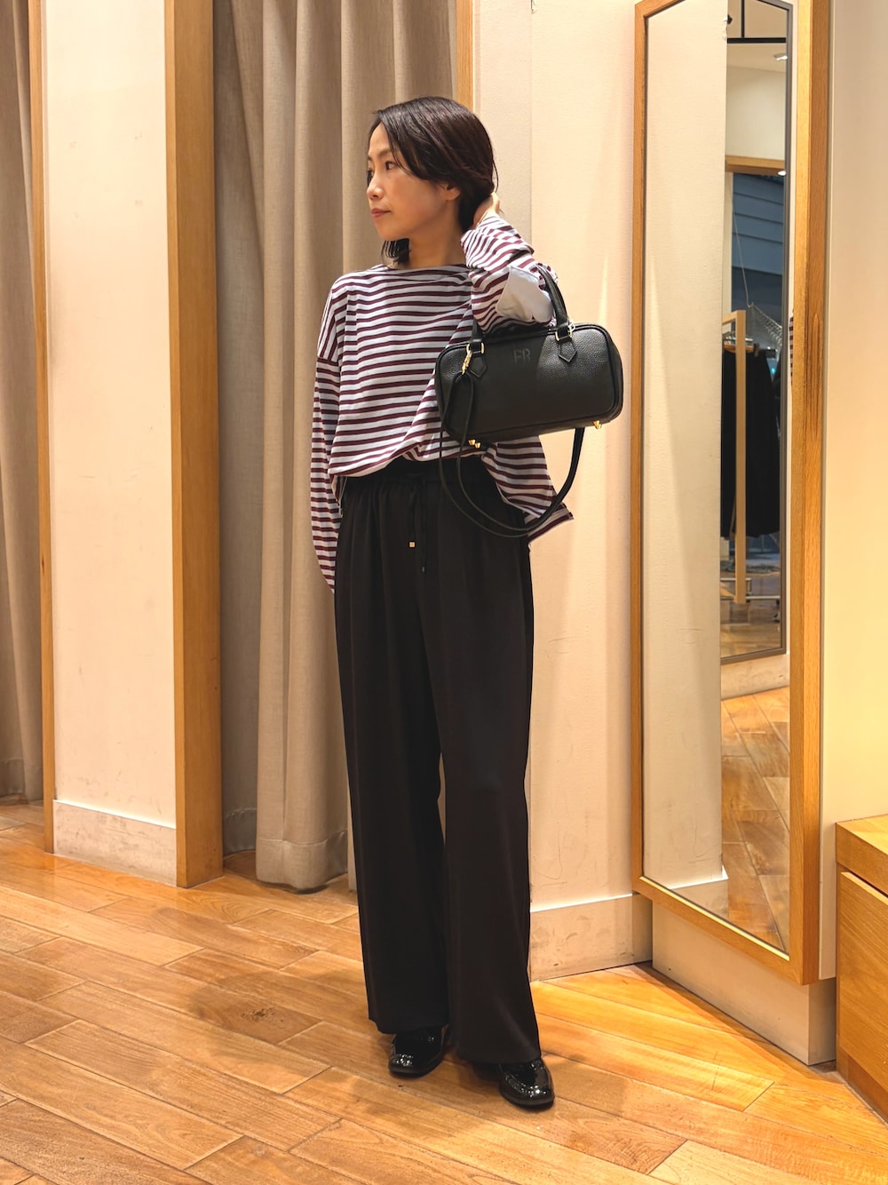 ブラック系のその他パンツ、ブルー系のTシャツ/カットソー、ブラック系のボストンバッグを着用したレディースの秋コーディネートの1枚目の写真