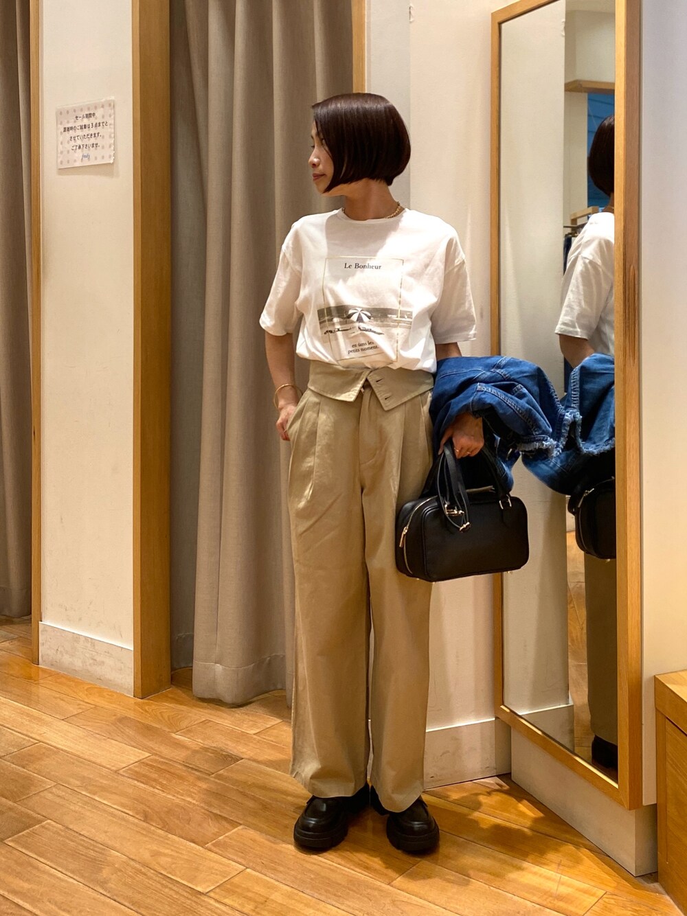 ベージュ系のチノパンツ、ブラック系のショルダーバッグ、ホワイト系のTシャツ/カットソーを着用したレディースの夏コーディネートの1枚目の写真