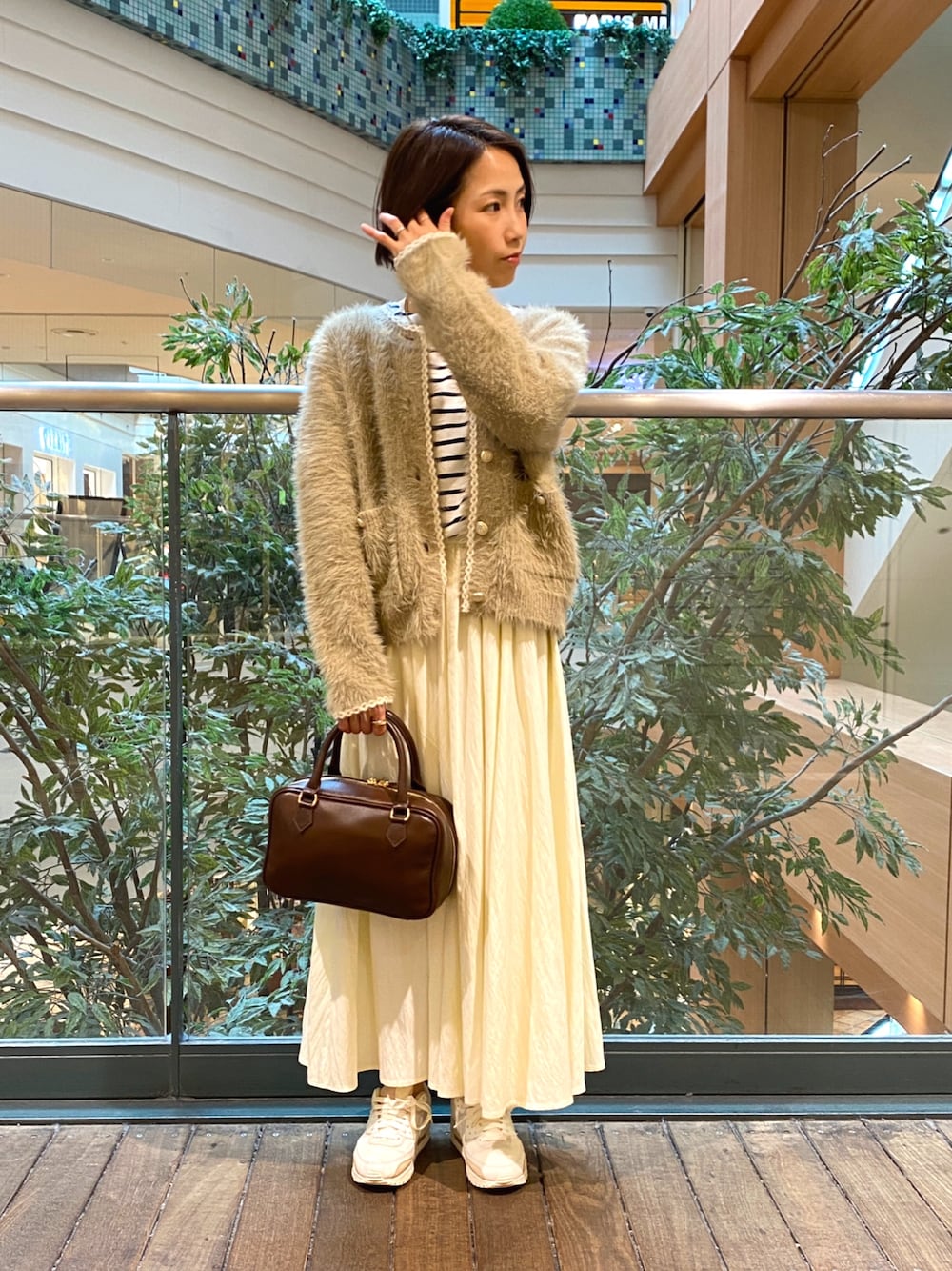 ベージュ系のカーディガン/ボレロ、ホワイト系のTシャツ/カットソー、ホワイト系のスカートを着用したレディースの秋コーディネートの1枚目の写真