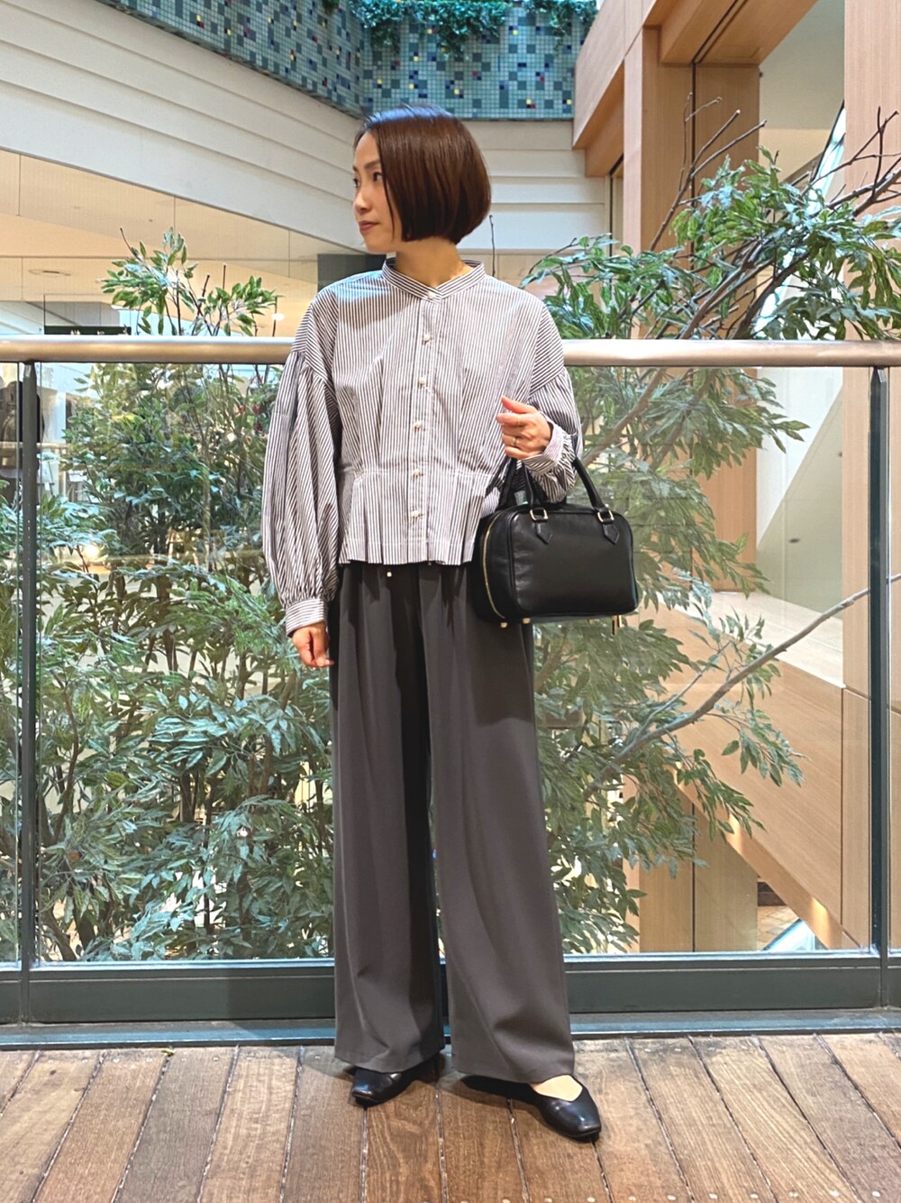 ブルー系のシャツ/ブラウス、ブラック系のハンドバッグ、グレー系のその他パンツを着用したレディースの秋コーディネートの1枚目の写真
