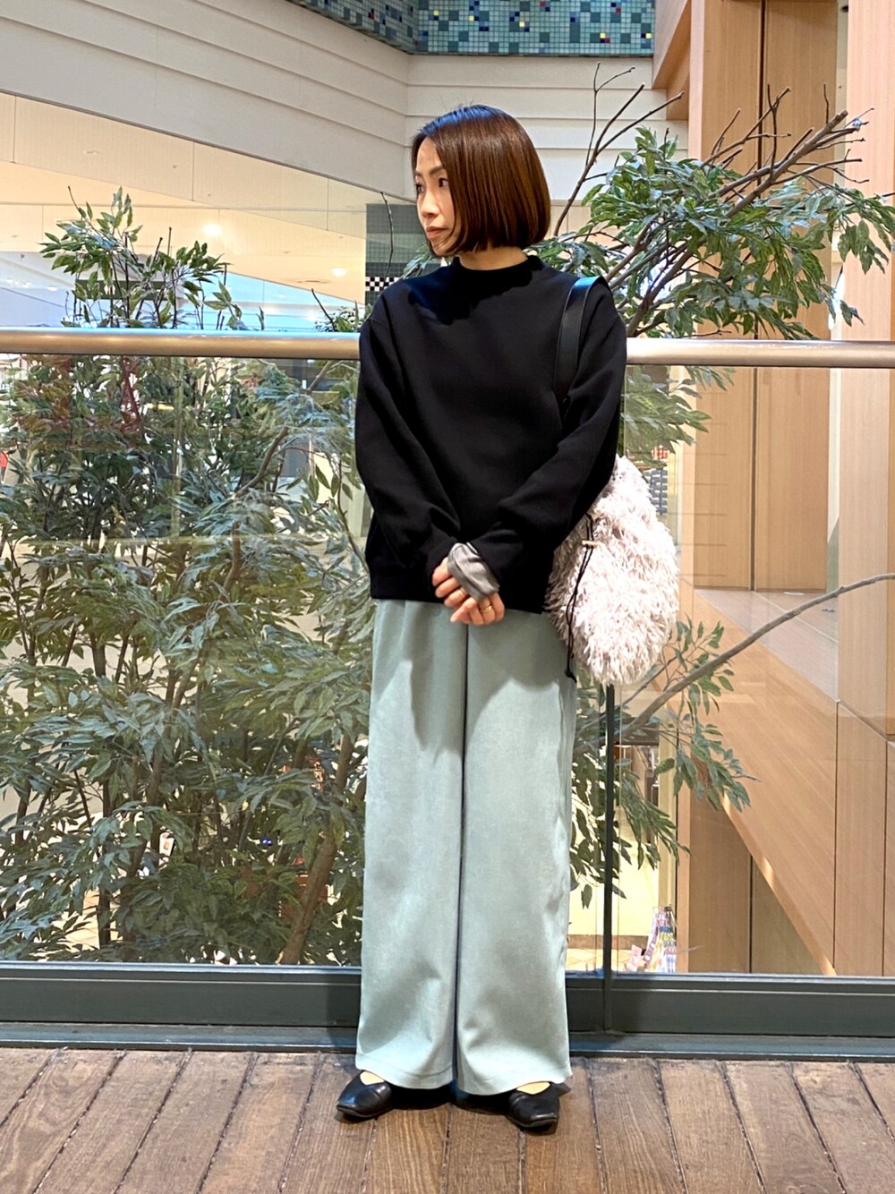 ブルー系のその他パンツ、グレー系のハンドバッグ、ブラック系のTシャツ/カットソーを着用したレディースの冬コーディネートの1枚目の写真