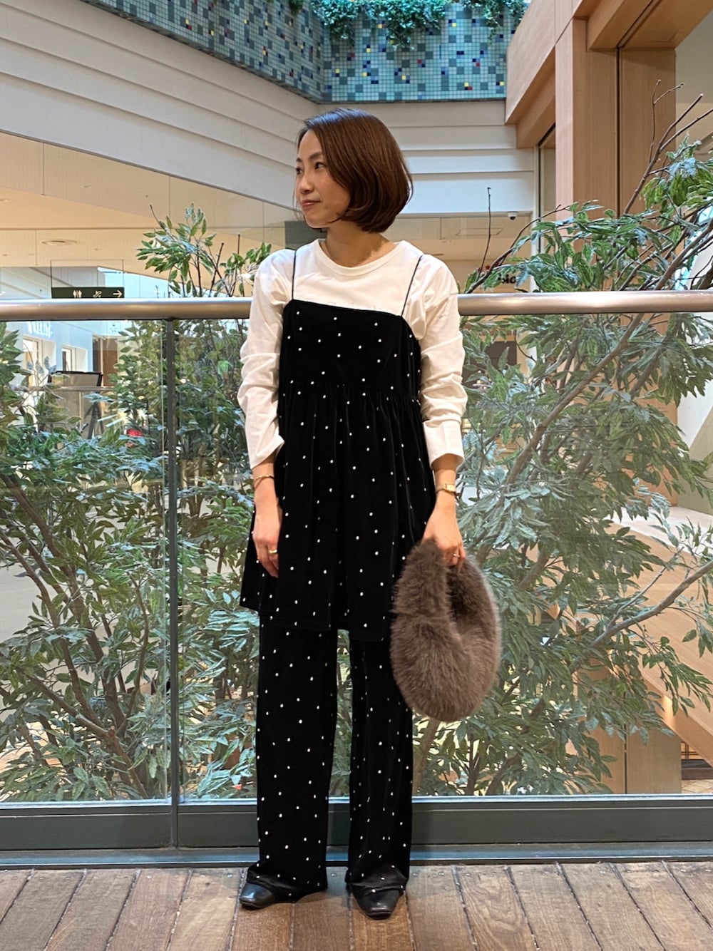 ブラック系のキャミソール、ホワイト系のTシャツ/カットソー、グレー系のハンドバッグを着用したレディースの秋コーディネートの1枚目の写真