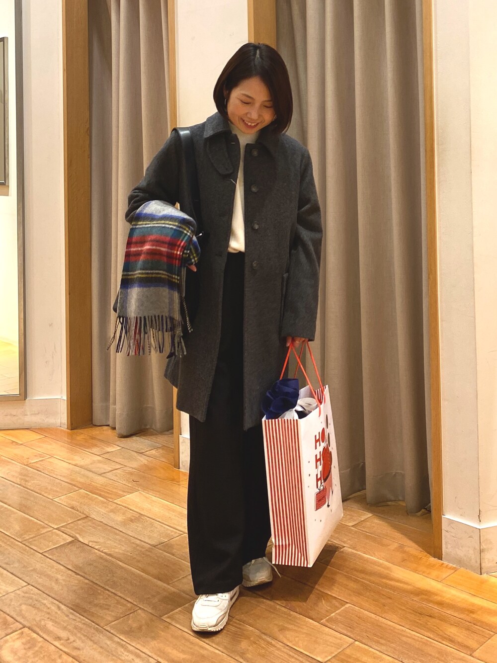 グレー系のダッフルコート、ホワイト系のTシャツ/カットソー、ブラック系のその他パンツを着用したレディースの冬コーディネートの1枚目の写真