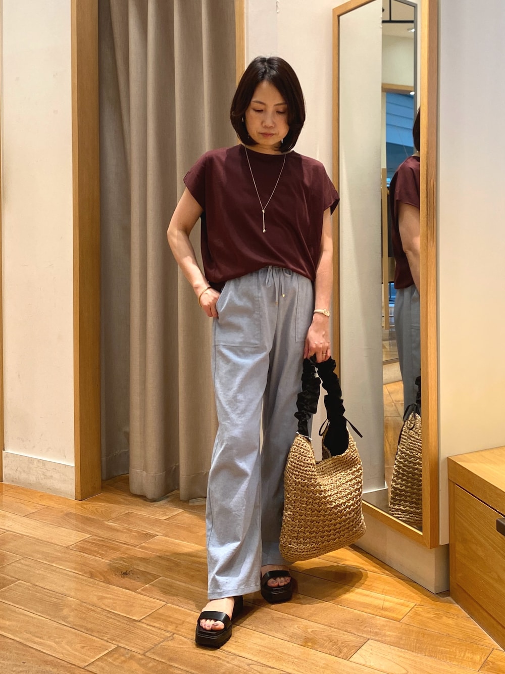 ブラウン系のTシャツ/カットソー、ブラック系のショルダーバッグ、ゴールド系のネックレスを着用したレディースの夏コーディネートの1枚目の写真
