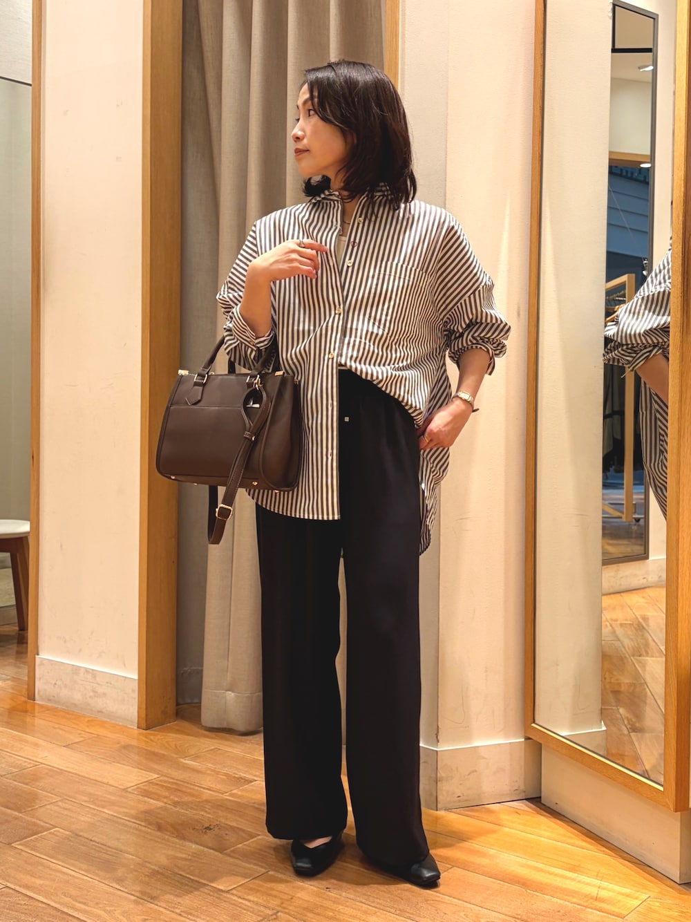 ブラック系のその他パンツ、ブラウン系のシャツ/ブラウス、ブラウン系のボストンバッグを着用したレディースの秋コーディネートの1枚目の写真
