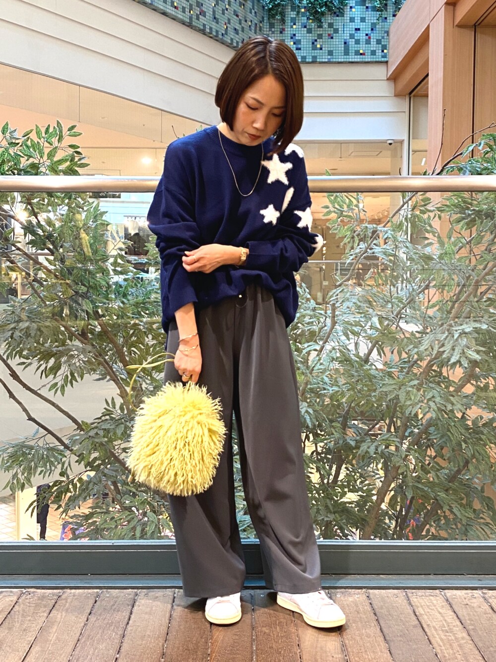ブルー系のニット/セーター、グレー系のその他パンツ、イエロー系のショルダーバッグを着用したレディースの秋コーディネートの1枚目の写真