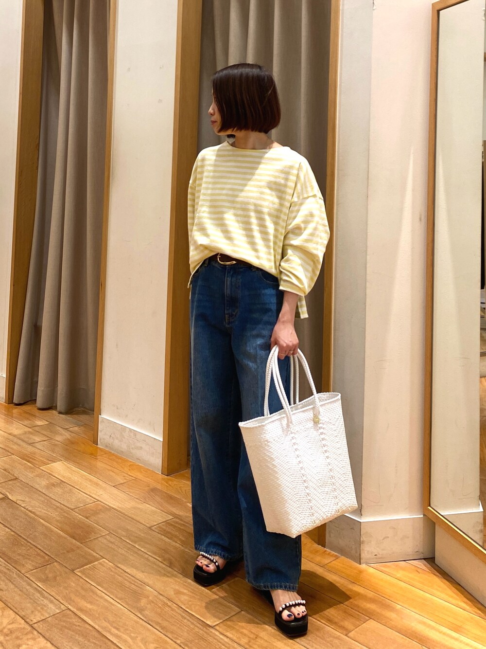 イエロー系のTシャツ/カットソー、ブルー系のデニムパンツ、ホワイト系のかごバッグを着用したレディースの春コーディネートの1枚目の写真