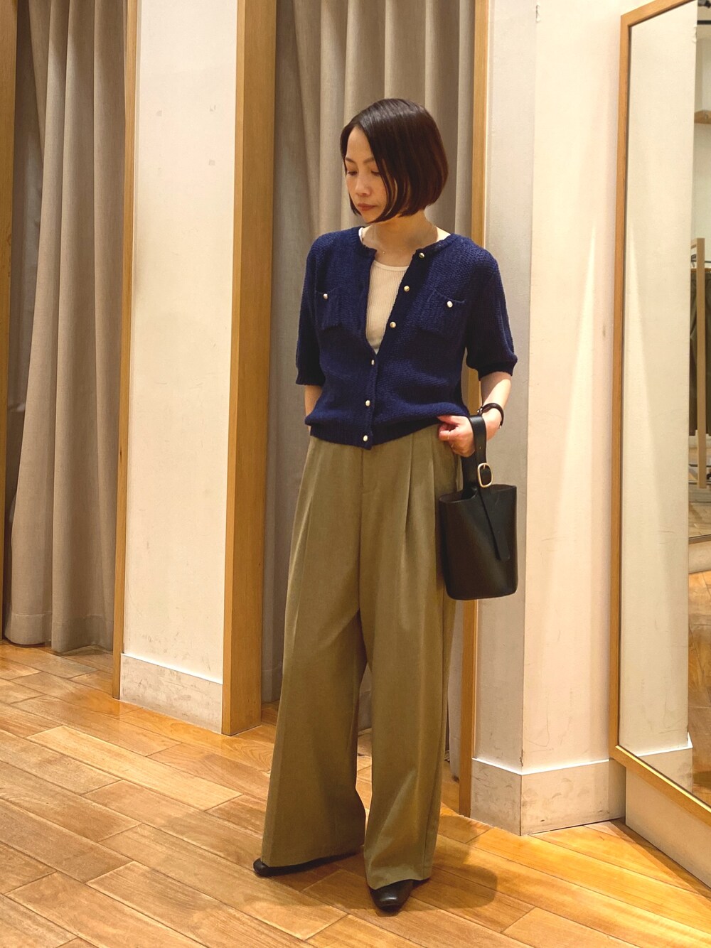 ブルー系のカーディガン/ボレロ、ホワイト系のTシャツ/カットソー、イエロー系のスラックスを着用したレディースの春コーディネートの1枚目の写真