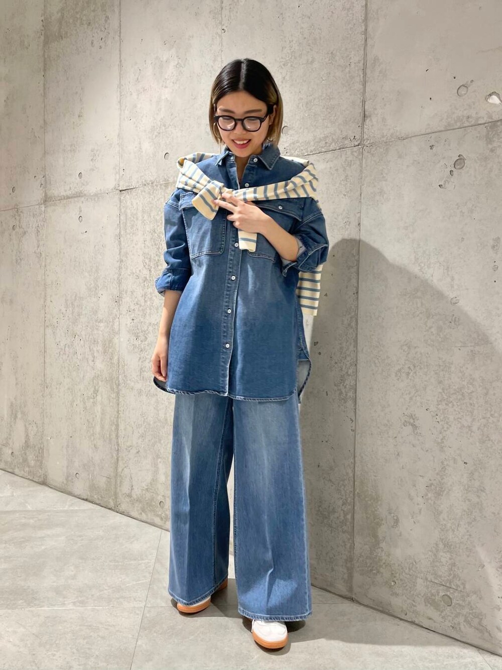 ブルー系のデニムパンツ、ブルー系のニット/セーター、ブルー系のシャツ/ブラウスを着用したレディースの冬コーディネートの1枚目の写真