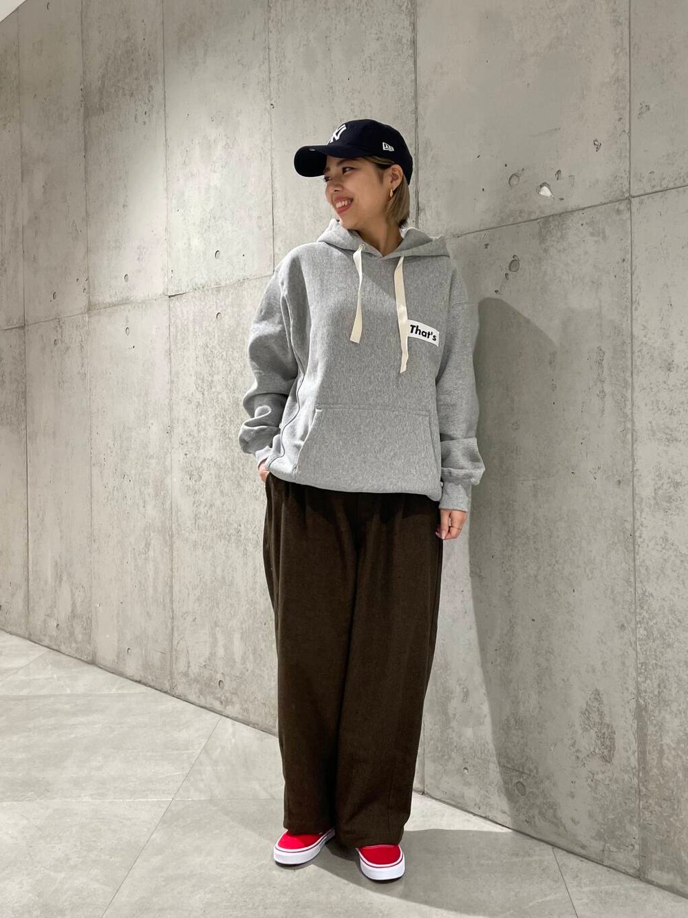 グレー系のパーカー、ブラウン系のその他パンツ、レッド系のスニーカーを着用したレディースの冬コーディネートの1枚目の写真
