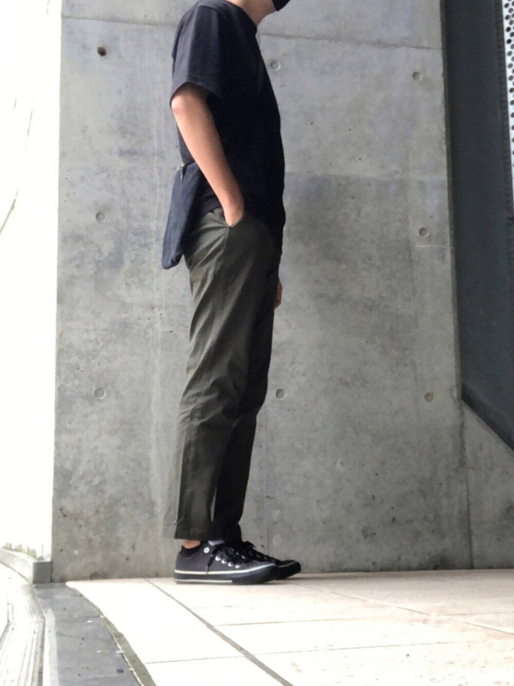 ブラック系のTシャツ/カットソー、ブラック系のバッグ、グリーン系のチノパンツを着用したメンズの夏コーディネートの1枚目の写真