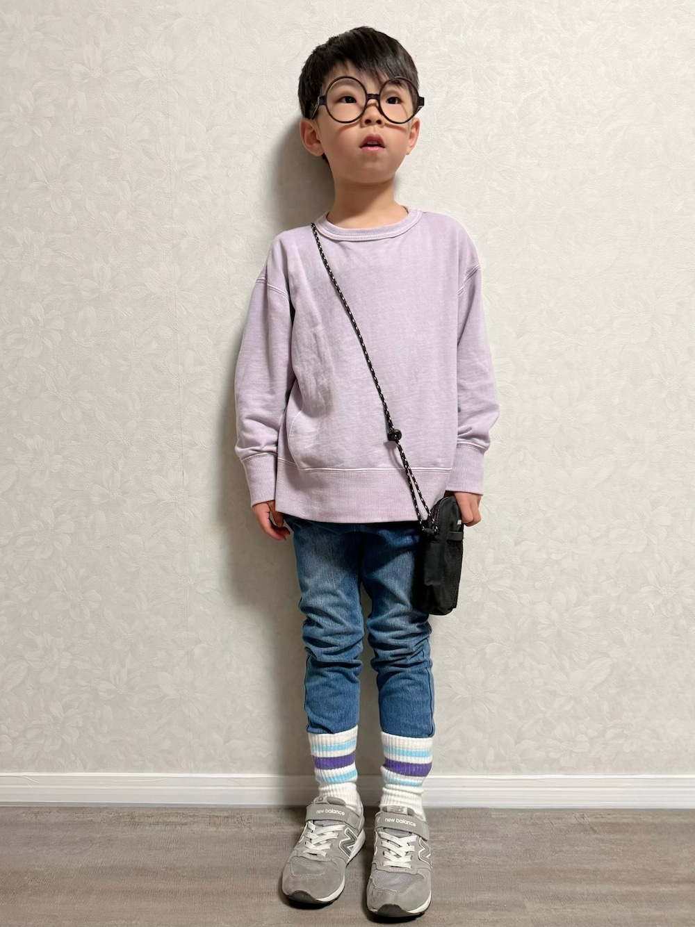 ブルー系のデニムパンツ、パープル系のスウェット、グレー系のスニーカーを着用したキッズの春コーディネートの1枚目の写真