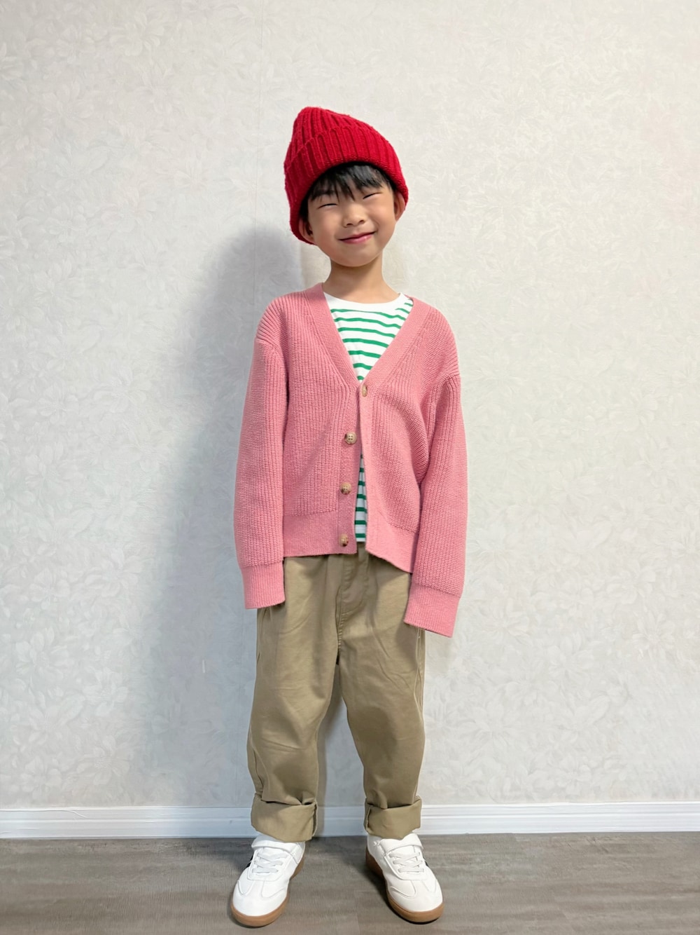 グリーン系のTシャツ/カットソー、ピンク系のカーディガン/ボレロ、ベージュ系のチノパンツを着用したキッズの春コーディネートの1枚目の写真