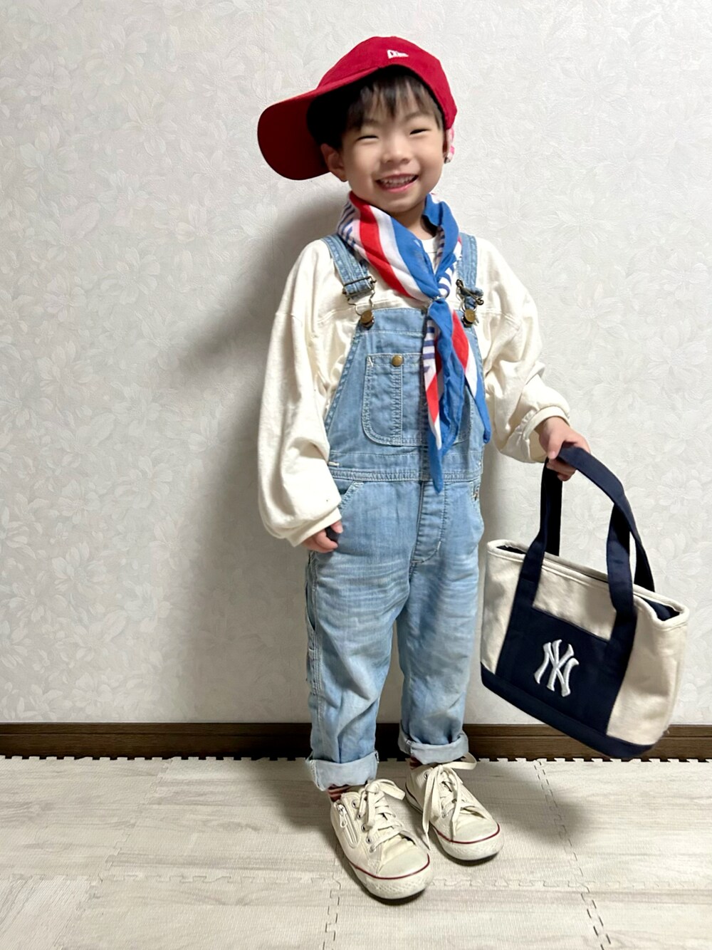 ホワイト系のTシャツ/カットソー、ブルー系のサロペット/オーバーオール、ホワイト系のショルダーバッグを着用したキッズの春コーディネートの1枚目の写真