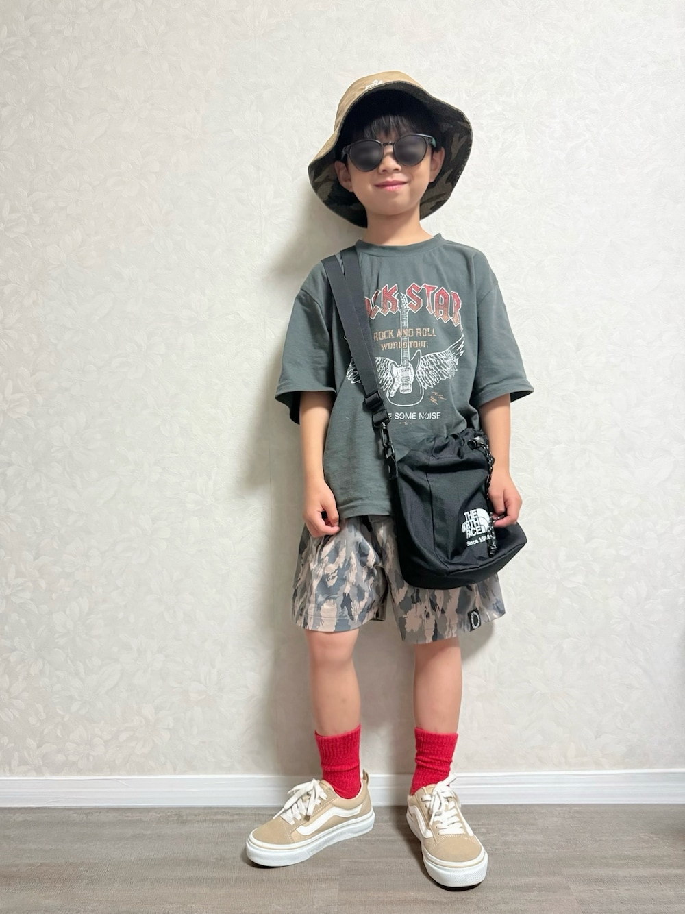 グレー系のTシャツ/カットソー、グリーン系のその他パンツ、ブラック系のショルダーバッグを着用したキッズの夏コーディネートの1枚目の写真