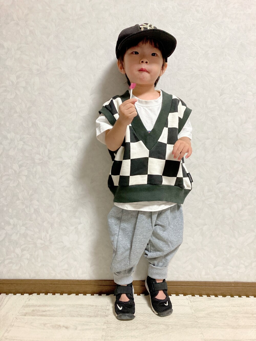 ホワイト系のTシャツ/カットソー、ブラック系のベスト、グレー系のスウェットパンツを着用したキッズの秋コーディネートの1枚目の写真