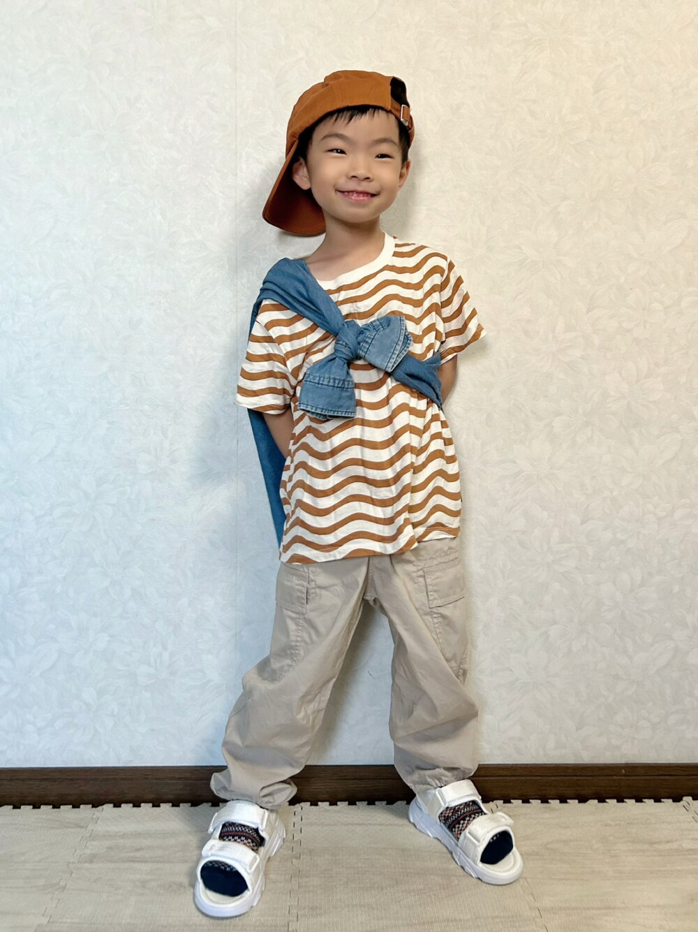 ベージュ系のTシャツ/カットソー、ブルー系のシャツ/ブラウス、ベージュ系のカーゴパンツを着用したキッズの秋コーディネートの1枚目の写真