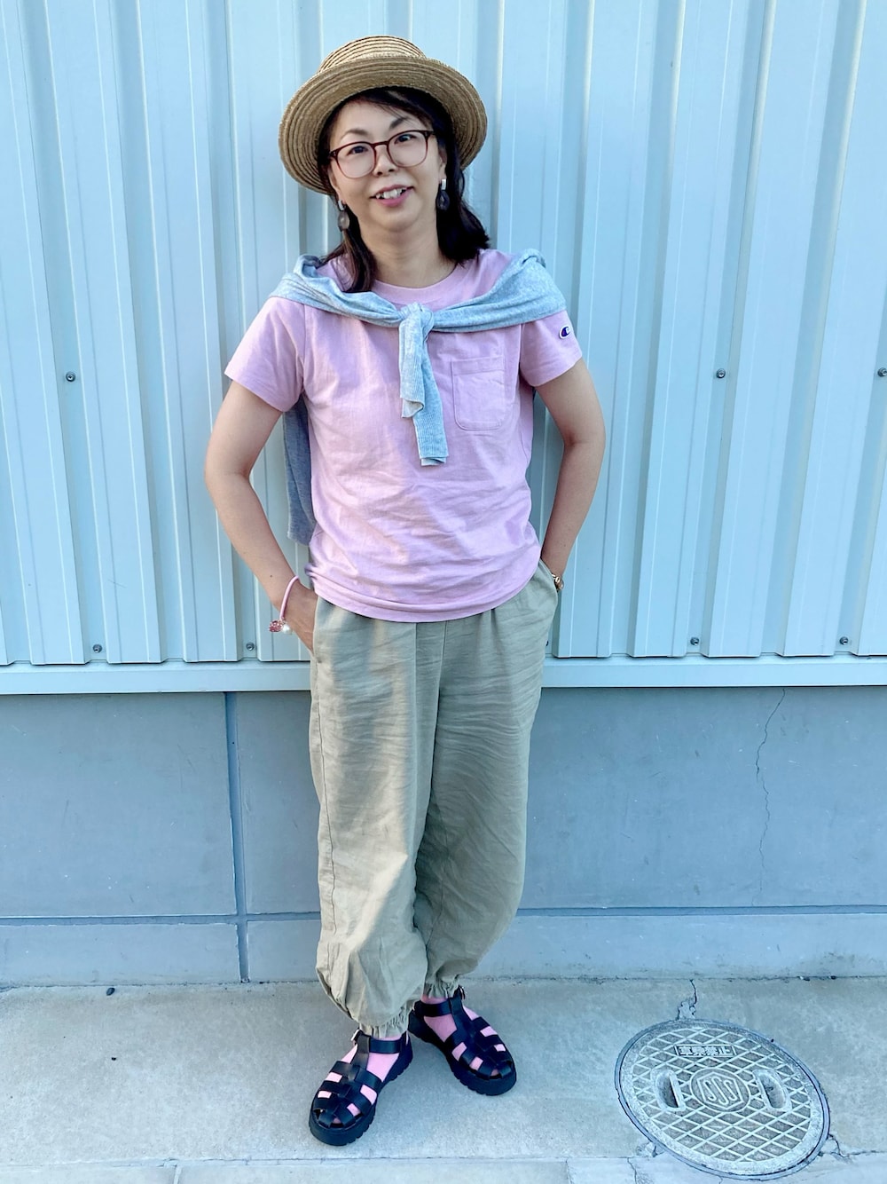 ピンク系のTシャツ/カットソー、グレー系のカーディガン/ボレロ、ベージュ系のパンツを着用したレディースの夏コーディネートの1枚目の写真